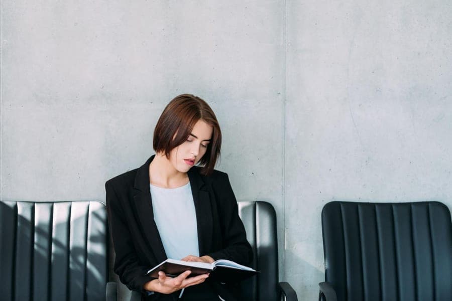 Mujer repasando sus notas mientras espera una entrevista